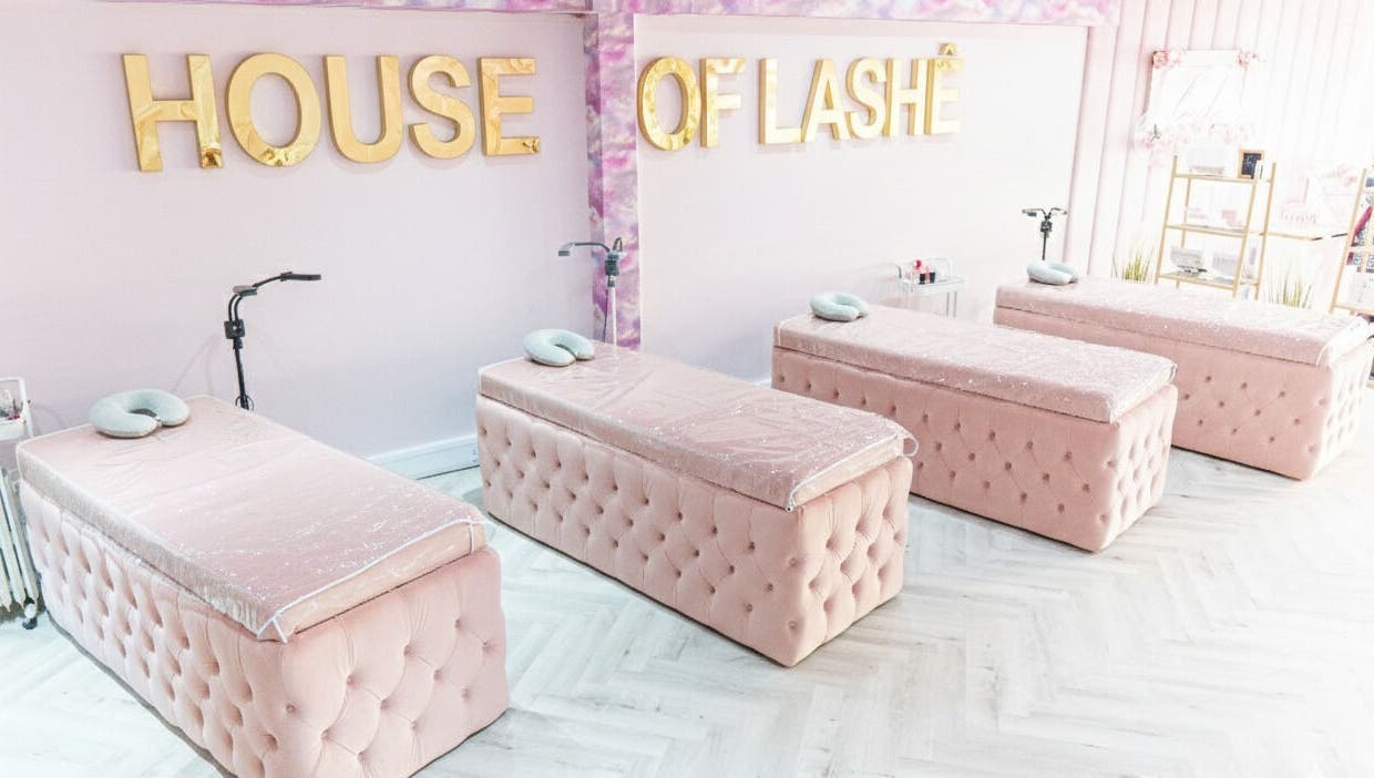 House of Lashè studio with pink treatment beds and gold signage